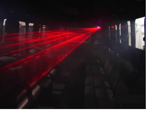 Red laser lighting show inside a party bus interior