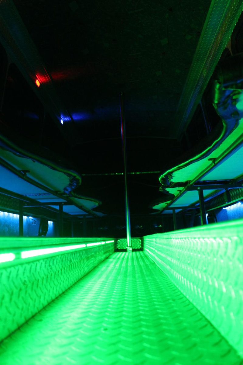 Emerald LED lighting down a party bus aisle