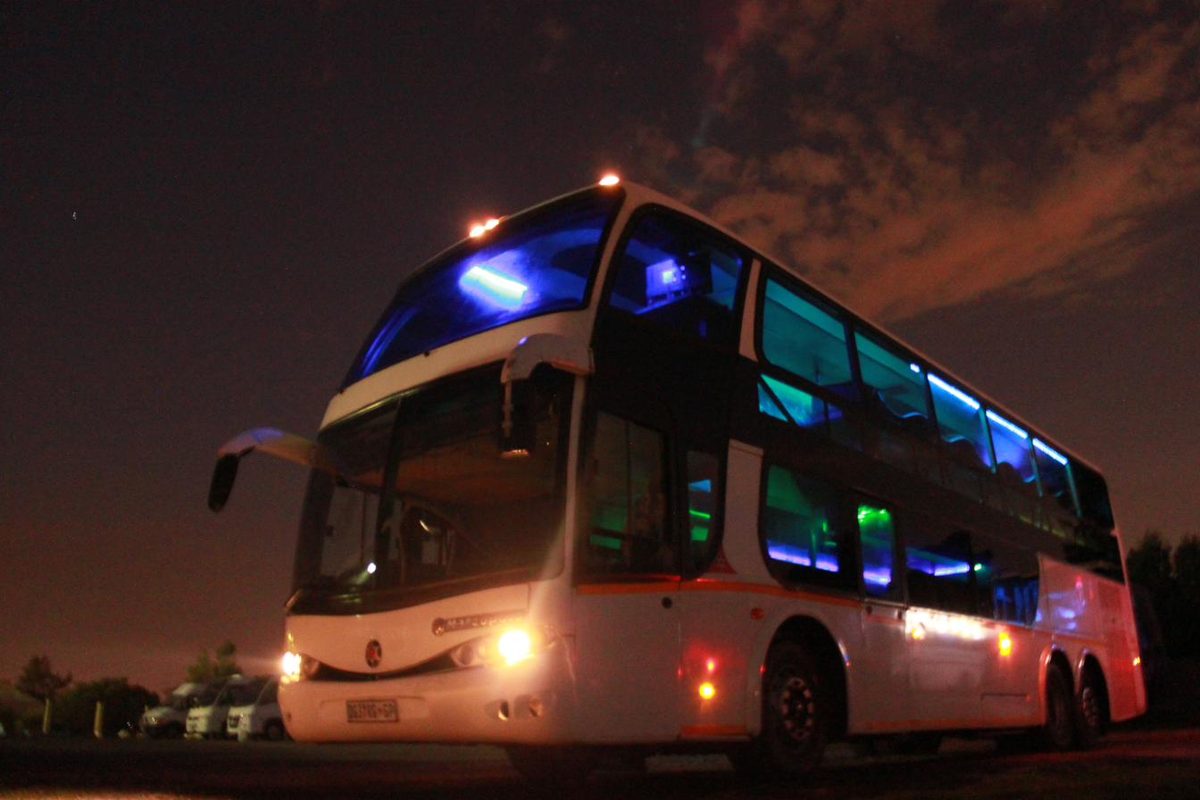 Double decker party bus lit up at night in Gauteng