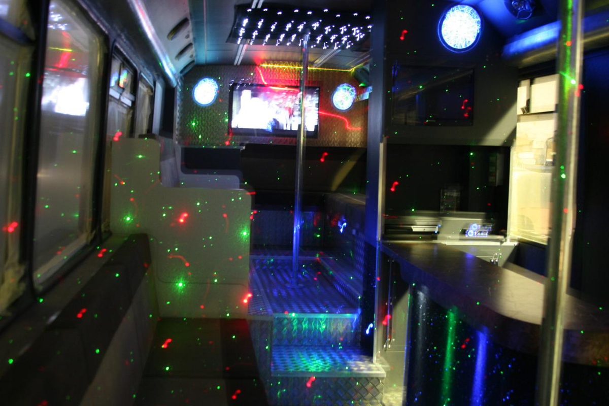 Party bus lounge with screens and booth seating