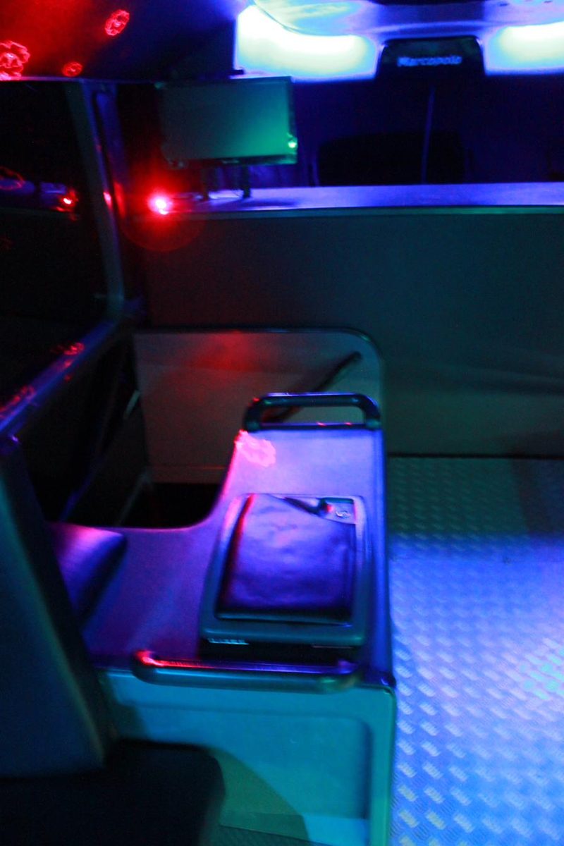 Booth seating with mood lighting inside a party bus
