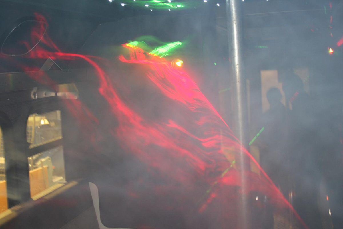 Red laser beams through smoke inside a party bus